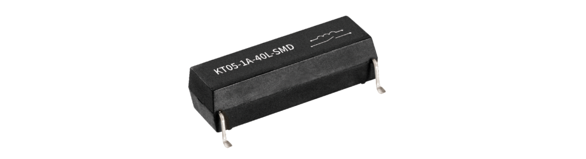 A black, rectangular Standex Detect electronic component with four metal pins, labeled KT03-1A-40L-SMD, is shown against a white background. by Standex Detect