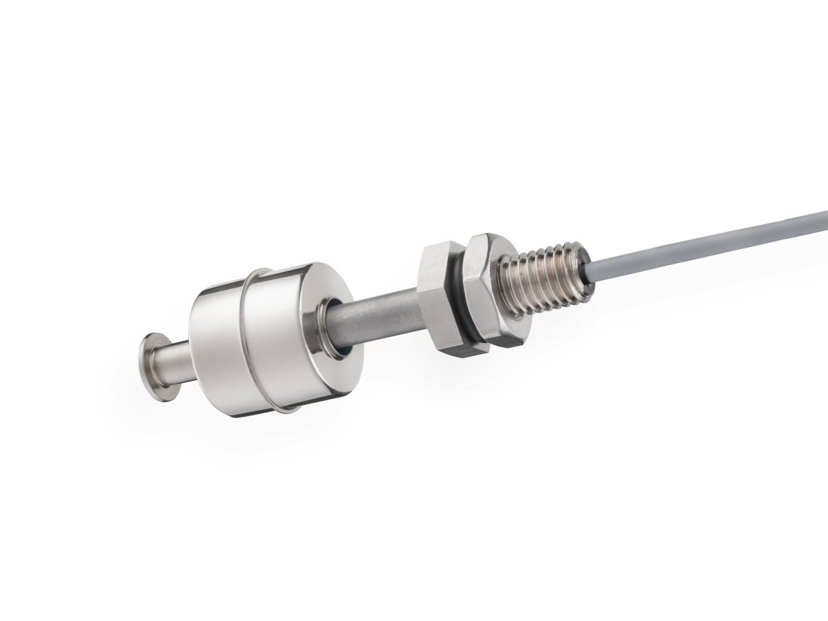 A close-up view of a metallic cylindrical liquid level sensor or float switch with a cable attached, featuring a threaded section and a hexagonal nut for mounting. The device is isolated on a white background. by Standex Detect
