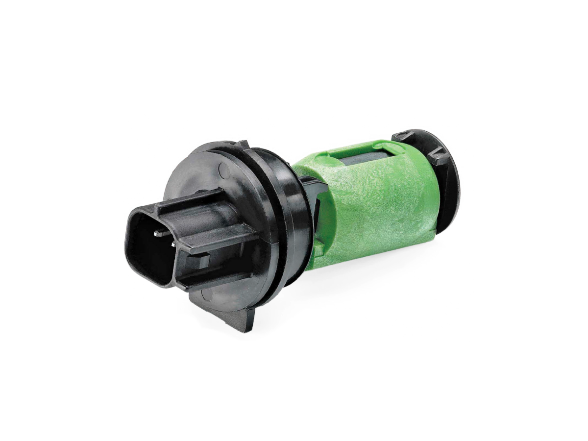 A close-up of a green and black R12456 Series Liquid Level Sensor, shown against a white background. The component features a cylindrical green body and black plastic ends with a visible electrical connector. by Standex Detect