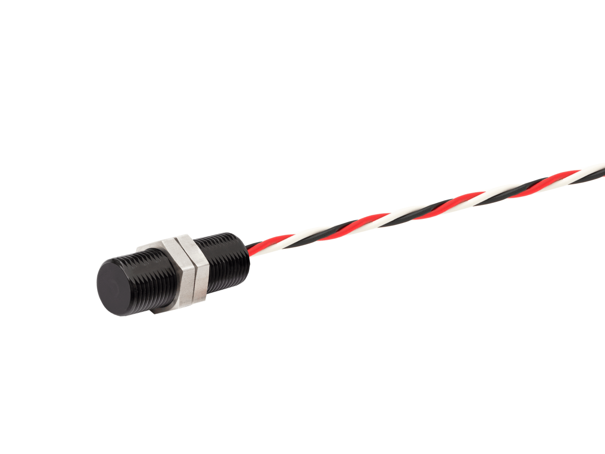 A cylindrical black Hall Switch sensor from the HS Series with threaded metal nuts attached, connected to a twisted pair of red, black, and white wires, isolated on a white background. by Standex Detect