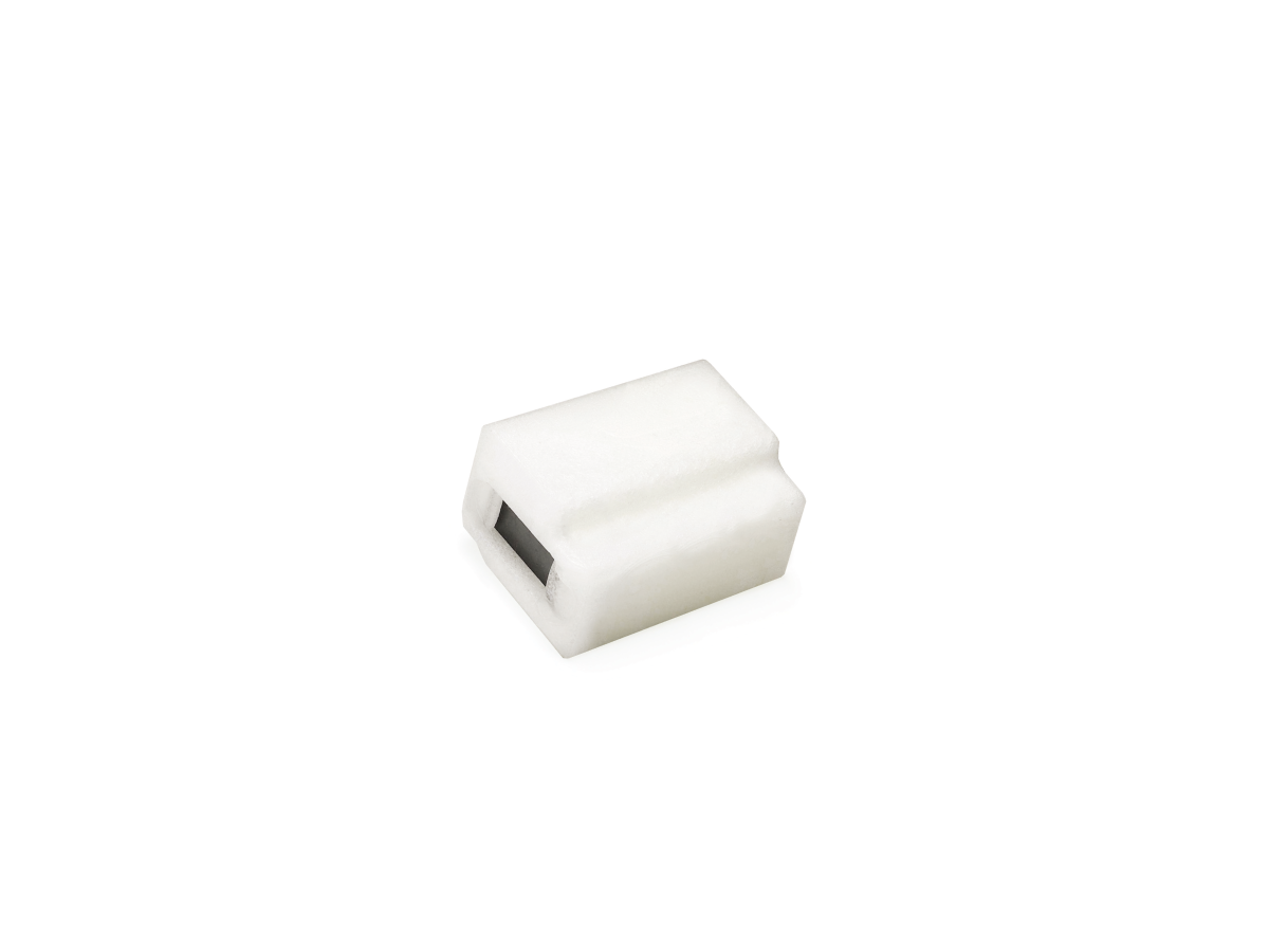 A small, white, rectangular plastic object from the B12450 Series with a black rectangular opening on one side, possibly housing a magnetic float, displayed against a plain white background. by Standex Detect