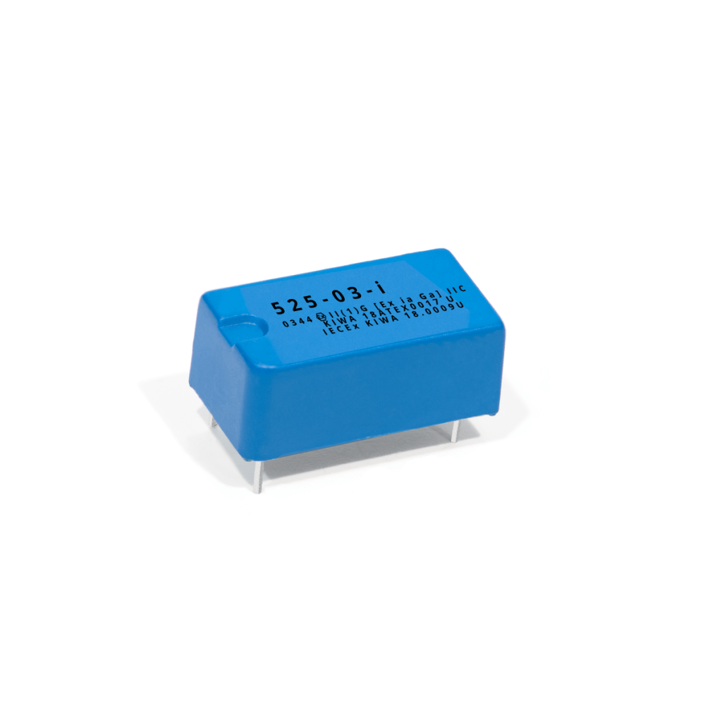 A blue rectangular electronic component with four metal pins on the bottom and black text printed on the top, certified to IECEx standards, placed on a white background. by Standex Detect