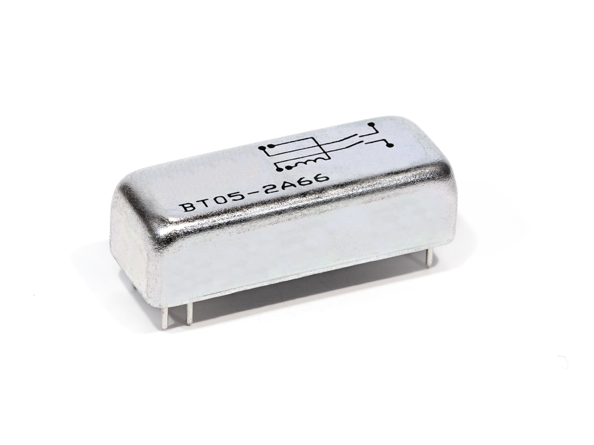 A small, rectangular metal electronic component from the BT Series with four pins, labeled BT05-2466 and featuring a simple schematic on top, isolated on a white background—ideal for Reed Relay applications. by Standex Detect