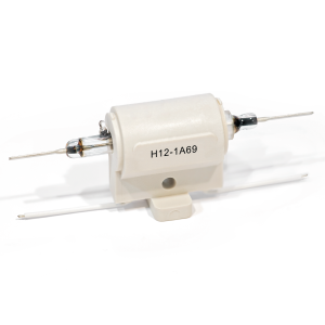 A white H Series reed relay with metal rods extending from both sides, labeled H12-1A69, mounted on a plastic base with a hole for securing. by Standex Detect