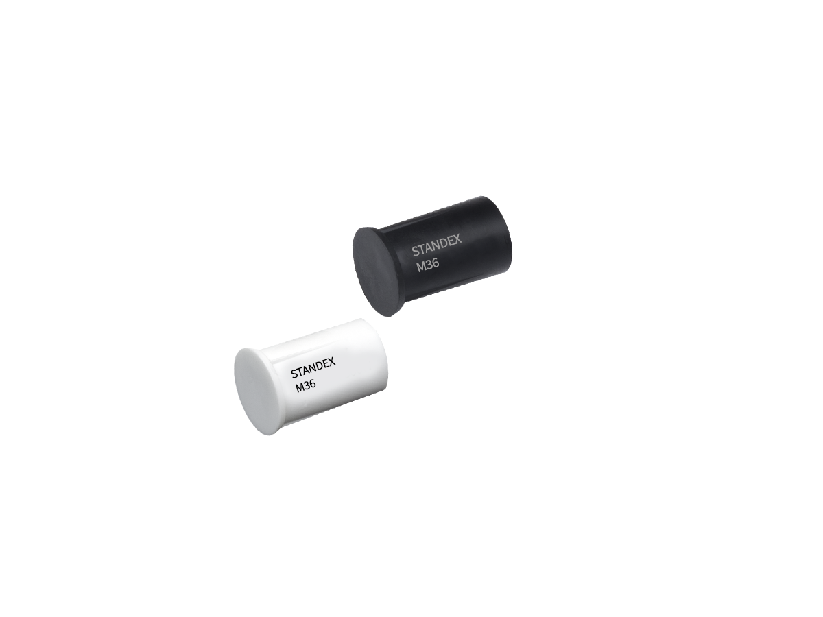 Two cylindrical electronic components, one black and one white, each labeled STANDEX M36, from the M36 Series Magnet range, are positioned diagonally on a plain white background. by Standex Detect